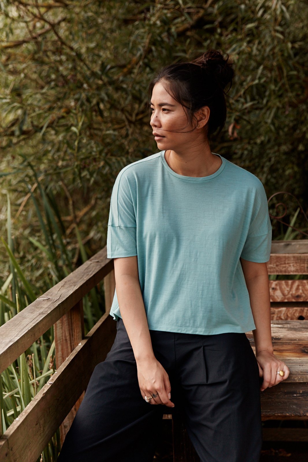 Woman wearing the Asmuss Boxy Cropped T-shirt in Sea Green.  Stylish and sustainable clothing for travel or everyday wear