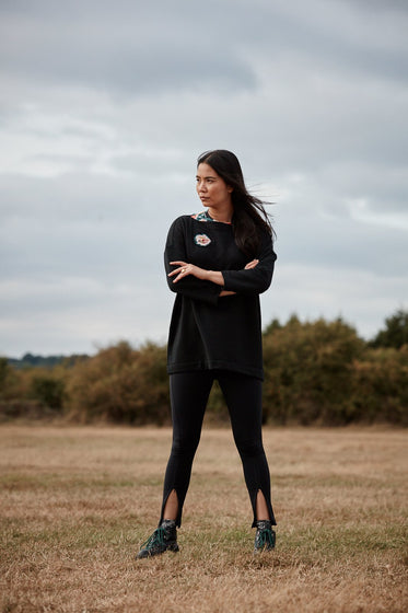 Woman wearing the Asmuss Twisted Legging with front zip detail. Use them for exercise or use them to layer up your own unique style.