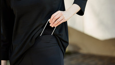 Showing how the kangaroo pocket in the waistband of the Asmuss Twisted Leggings holds a phone.