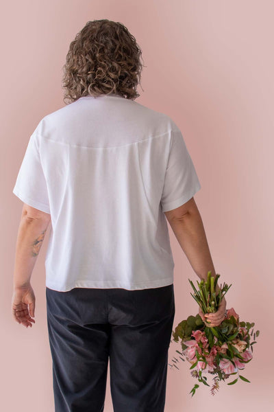 Back view of Asmuss Panelled T-shirt in White Organic Cotton and Recycled Polyester worn by Clare with a beautiful bunch of flowers.