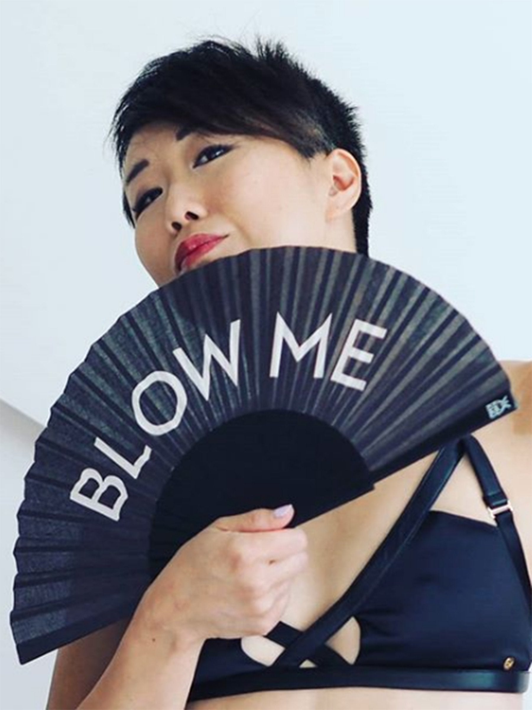 Model with short black hair wearing black underwear holds the Khu Khu Blow Me Hand-Fan