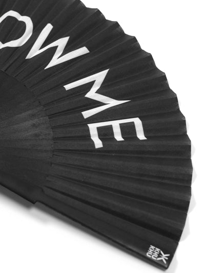 Close up of Khu Khu Blow Me Hand-Fan. White Font BLOW ME on black background with black wooden sticks and black rivet. 