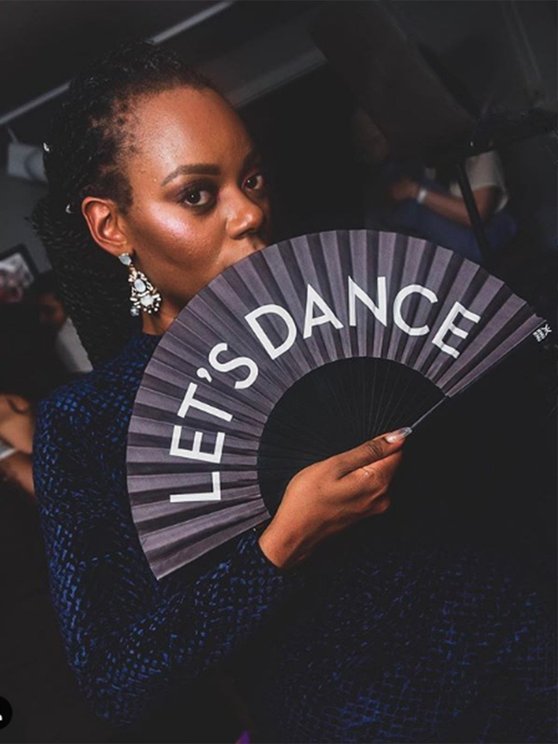 Model wears Khu Khu Let's Dance fan at party.