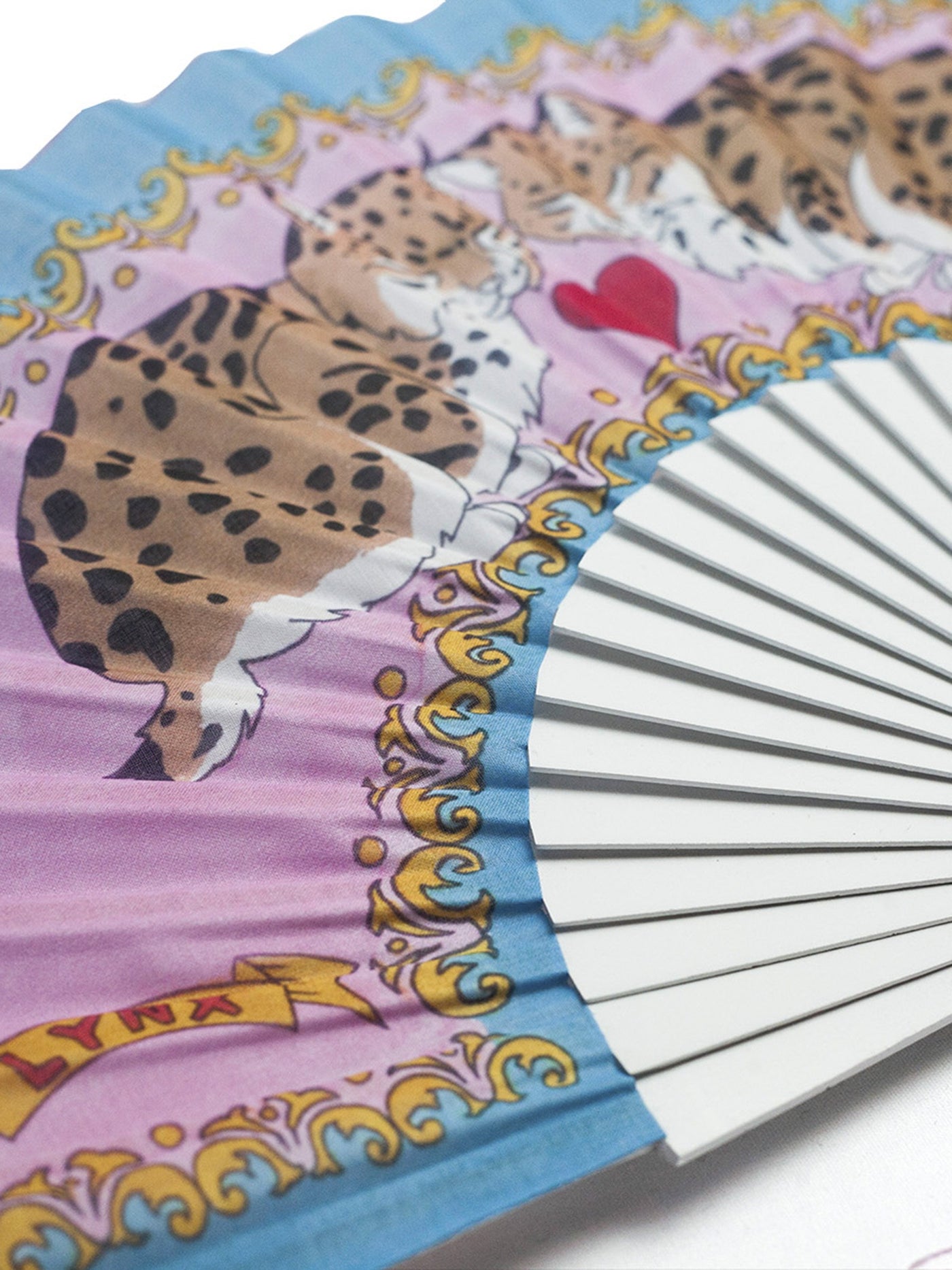Close up of Love Lynx Hand-Fan from Khu Khu with 2 symmetrical cats with a heart between them and the words lynx in bottom left corner 
